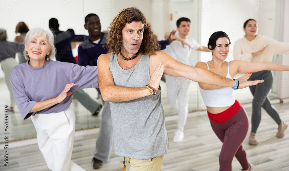 Group of dancing people practicing energetic swing during a class in a dance studio