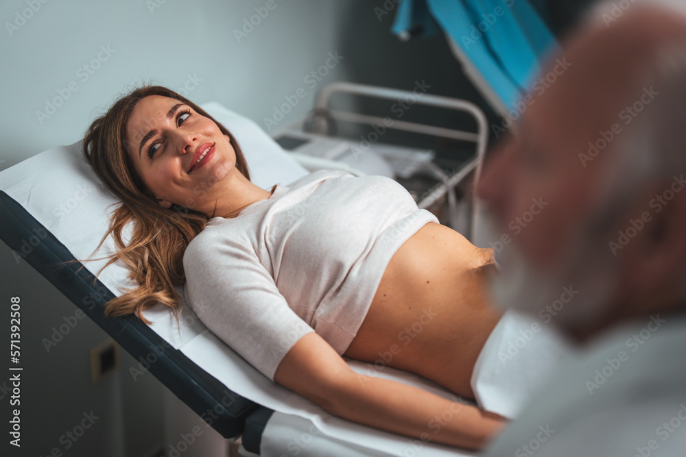 Obraz premium Sonographer using ultrasound machine at work. Modern clinical diagnostics and treatment. Close-up ultrasound scanner in hand of doctor. Doctor ultrasound examine female patient abdomen at hospital