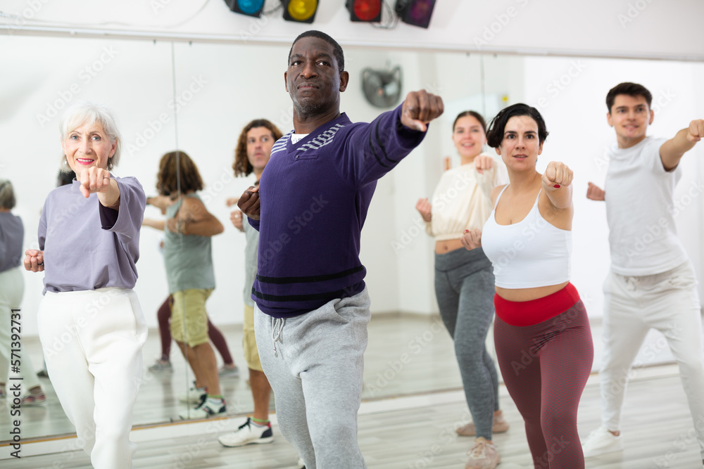 Happy african man learning new modern dance in group dance lesson