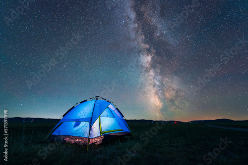 the blue tent is on the grassland. The tent is under the stars