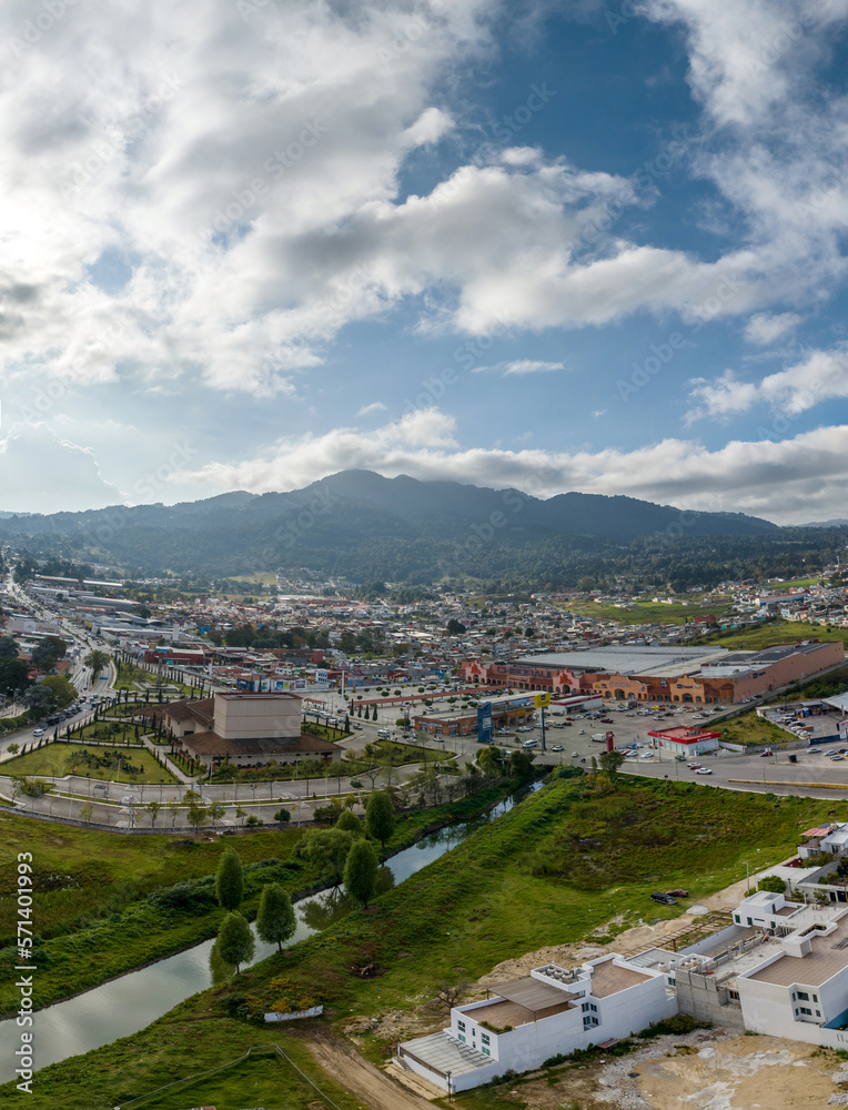 Aerial view of colorful mountain village of San Cristobal de Las Casas in Mexico. Clouds over the mountains. Panorama.