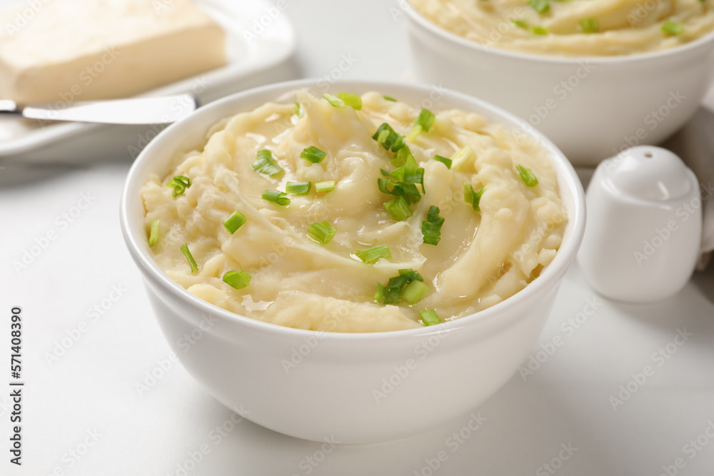 Bowls of delicious mashed potato with green onion on white table Bowls of delicious mashed potato with green onion on white table