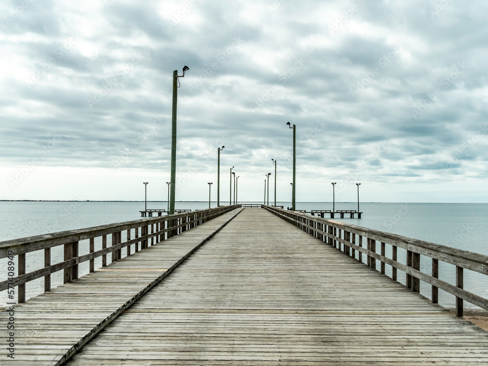 A wide empty pier with street lights