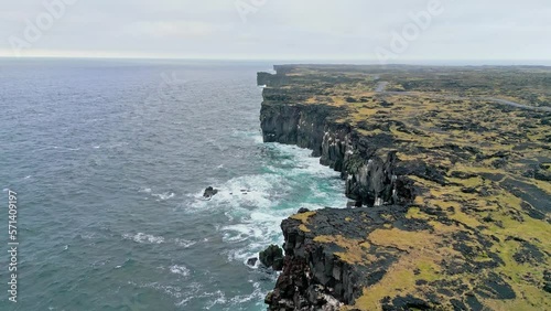 Stormy sea crashing in the cliffs on Icelandic coastline on a cold autumn day photo