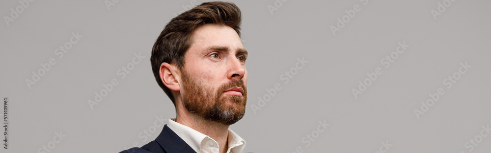 Obraz premium Serious business man in classic black suit with crossed hands looking at side