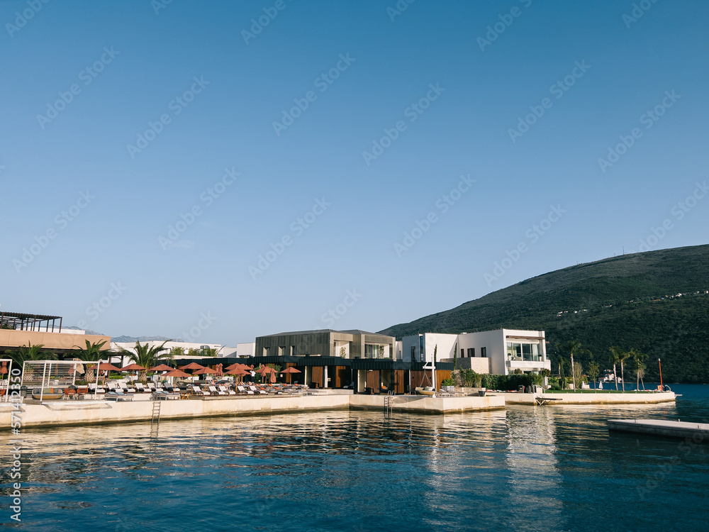 Private beach with sun umbrellas and sun loungers near the hotel by the sea