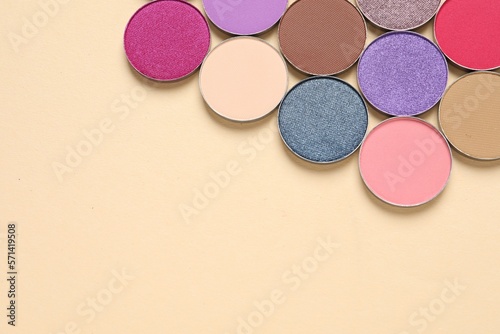 Different beautiful eye shadows on beige background, flat lay. Space for text