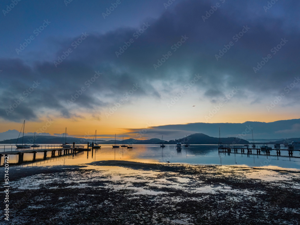 Fototapeta premium Soft and hazy aerial sunrise waterscape with boats