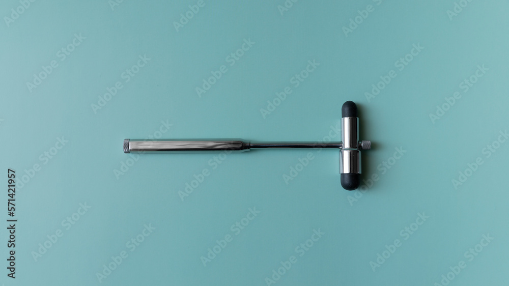 neurological hammer on a blue background. medical instrument on a turquoise background, medical equipment lies. neurological hammer on a blue background. medical instrument on a turquoise background, medical equipment lies.