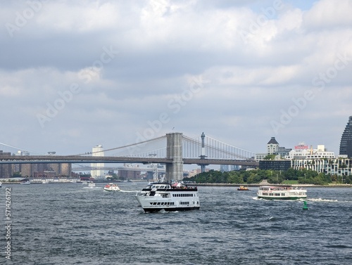 bridge shot with a boat in the river, with the city in the background united states of america, historical city new york, manhattan island © Eyestock