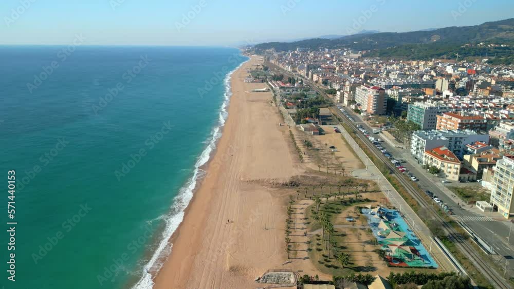 A bird's eye view of Pineda de Mar beach reveals a stunning seascape of crystal clear waters, sandy beaches and lush vegetation.