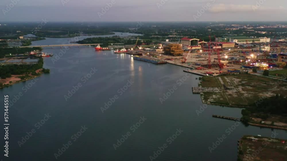 Dusk aerial tilt up shot capturing massive fabrication yard, plant and marine shipyard at Kampung Acheh Lumut port industrial park, ship building and repair hangars and hardstands, Perak, Malaysia. Dusk aerial tilt up shot capturing massive fabrication yard, plant and marine shipyard at Kampung Acheh Lumut port industrial park, ship building and repair hangars and hardstands, Perak, Malaysia.