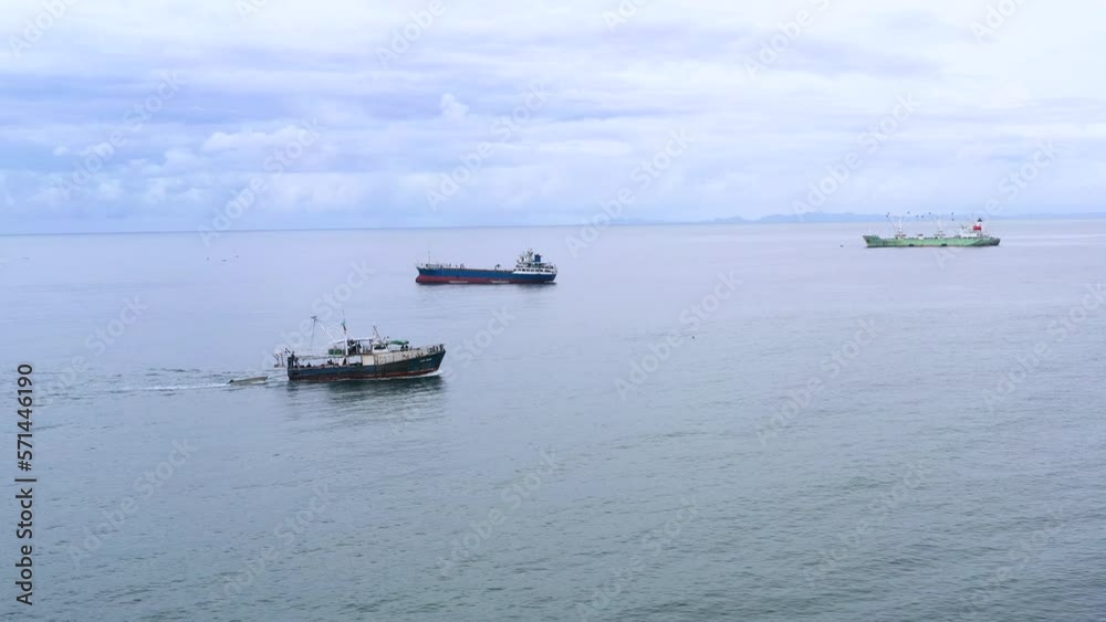 A ship travels past other ships in the harbour. A ship travels past other ships in the harbour.