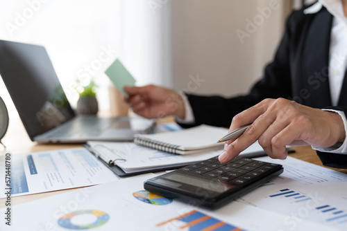 Asian business woman Calculate turnover with calculator. Take note. Have notepad to remember to do financial report or profit. Income tax. Idea concept. Accounting. Finance.