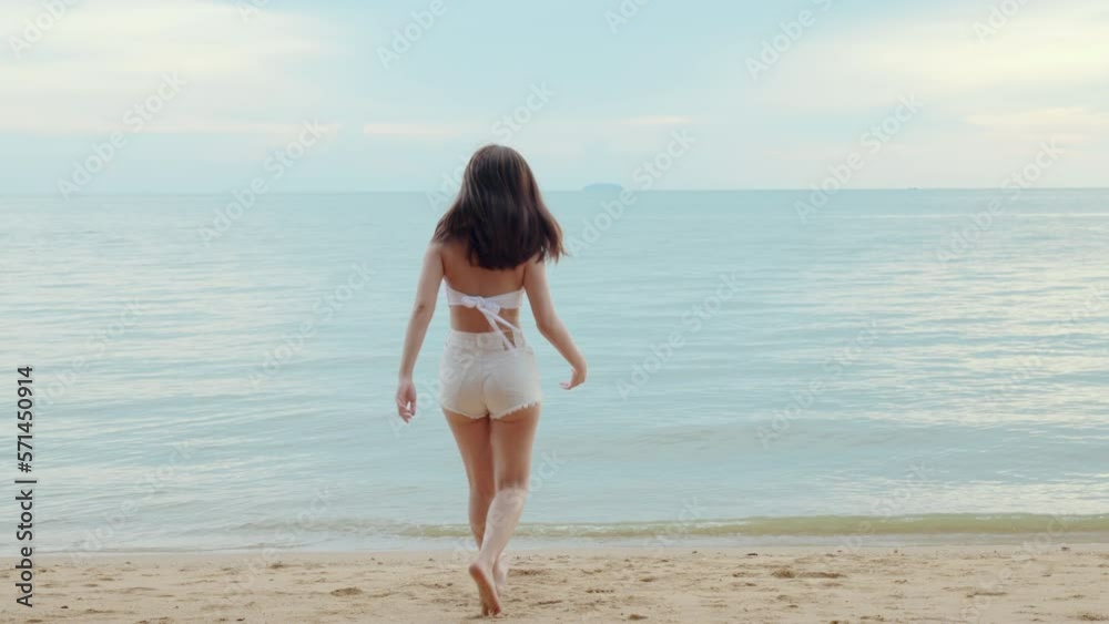 Beautiful Asian woman raising arms and enjoying freedom turn around at tropical paradise beach, Happy female in bikini swimsuit having fun open arms in summer vacation travel Beautiful Asian woman raising arms and enjoying freedom turn around at tropical paradise beach, Happy female in bikini swimsuit having fun open arms in summer vacation travel
