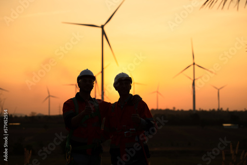 Engineers working on wind farms for renewable energy are responsible for maintaining large wind turbines. Returning from work during while the evening sun shines a beautiful golden light