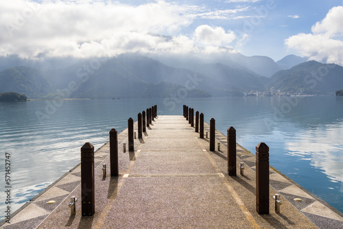 Large blue lake surrounded by mountains with pier in the morning at sun moon lake of Taiwan