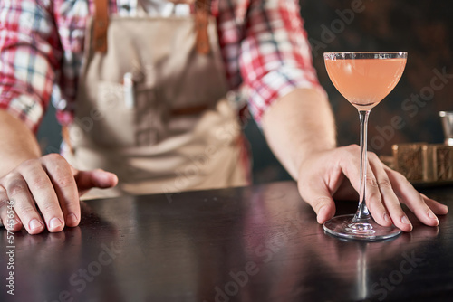 male bartender serves a ready-made alcoholic cocktail.