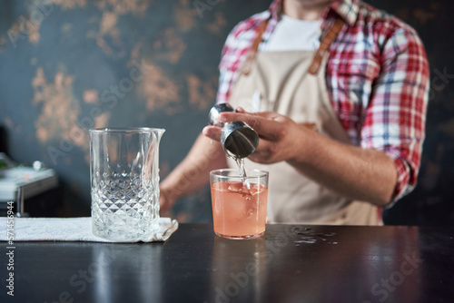 image of a bartender using a shaker to make a cocktail.