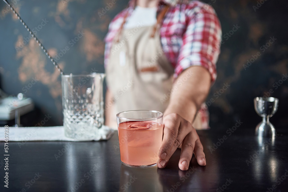 image of a cocktail glass in the hands of a bartender. image of a cocktail glass in the hands of a bartender.
