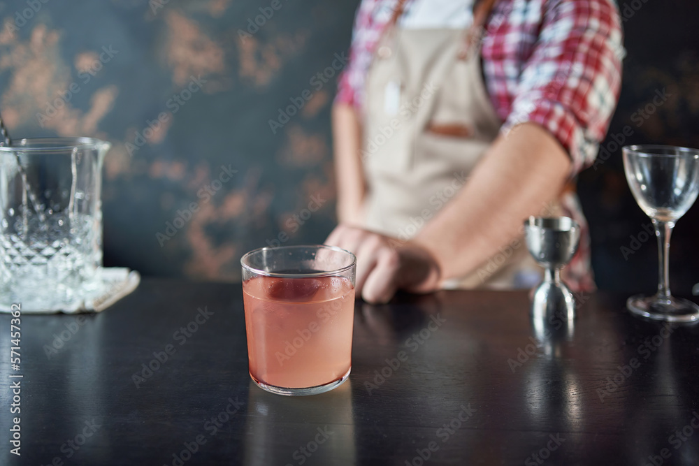 image of a cocktail glass in the hands of a bartender.