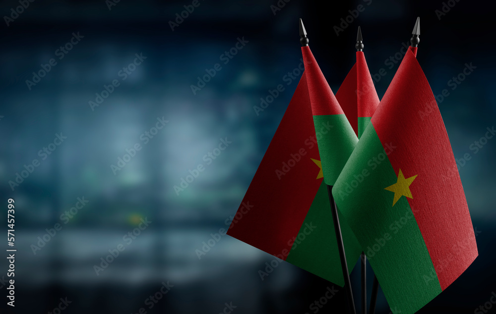 Small flags of the Burkina Faso on an abstract blurry background