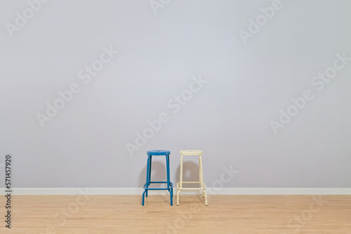 A blue chair and a beige iron frame chair are placed in a spacious living room