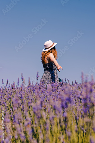Woman in a hat standing in lavender flowers field