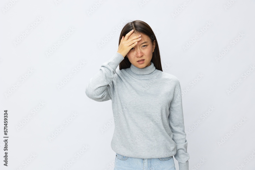 Asian woman holding her hand to her head for severe headache, migraine white background Asian woman holding her hand to her head for severe headache, migraine white background
