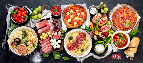 Italian food dishes on dark background.