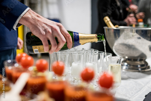Main de serveur qui sert du champagne pendant un cocktail photo