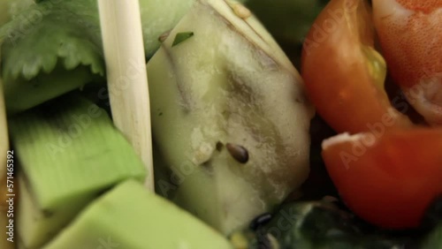 close-up of wooden sticks taking a piece of avocado. Shrimp. A plate of poke.