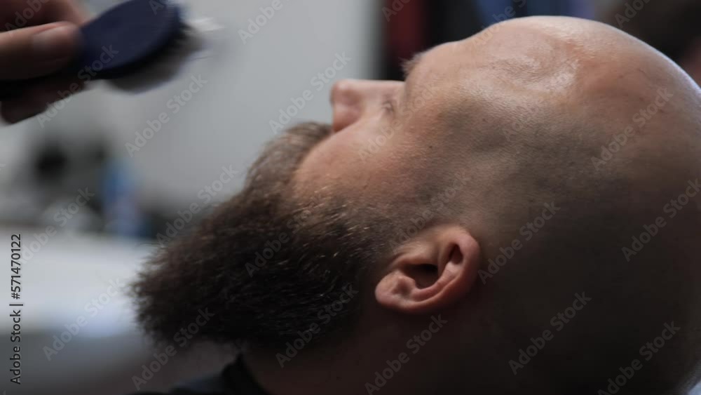 Young attractive bald man with long dark haired beard, laying on a chair in a barbershop. Barber brushing and trimming hair. Shot in profile.
Beautiful close up slow motion with neutral background Young attractive bald man with long dark haired beard, laying on a chair in a barbershop. Barber brushing and trimming hair. Shot in profile.
Beautiful close up slow motion with neutral background