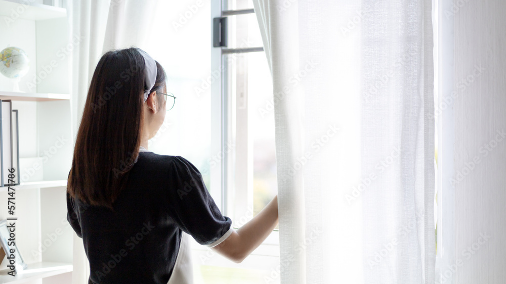 Cleaning woman opening window blinds to clean in morning light at living room, Big cleaning, Housework, Daily routine ,Removes germs and dirt and deep stains, Spray alcohol, Clean up on weekends. Cleaning woman opening window blinds to clean in morning light at living room, Big cleaning, Housework, Daily routine ,Removes germs and dirt and deep stains, Spray alcohol, Clean up on weekends.