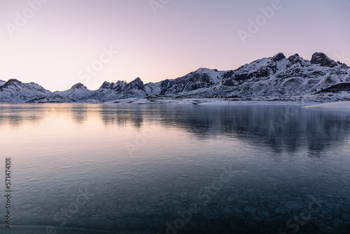 Frozen Casares Reservoir  Tres Mar  as Massif and Pe  as de Cubillas de Arbas at sunset. Leon  Spain.