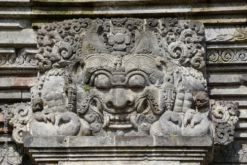 The relief of kala kirtimukha on penataran temple. Kala kīrttimukha is the name of a swallowing fierce monster face with huge fangs and a gaping mouth photo