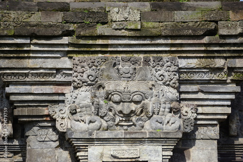 The relief of kala kirtimukha on penataran temple. Kala kīrttimukha is the name of a swallowing fierce monster face with huge fangs and a gaping mouth photo