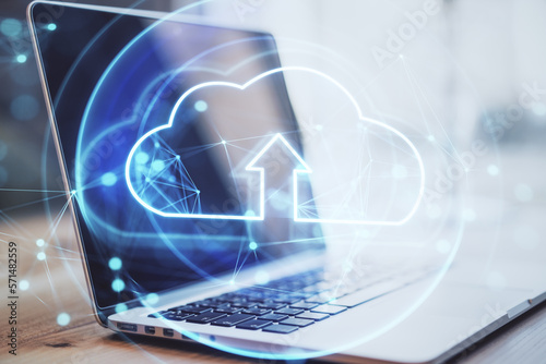 Internet data storage and computing network concept with digital glowing cloud symbol with arrow on modern laptop background, double exposure