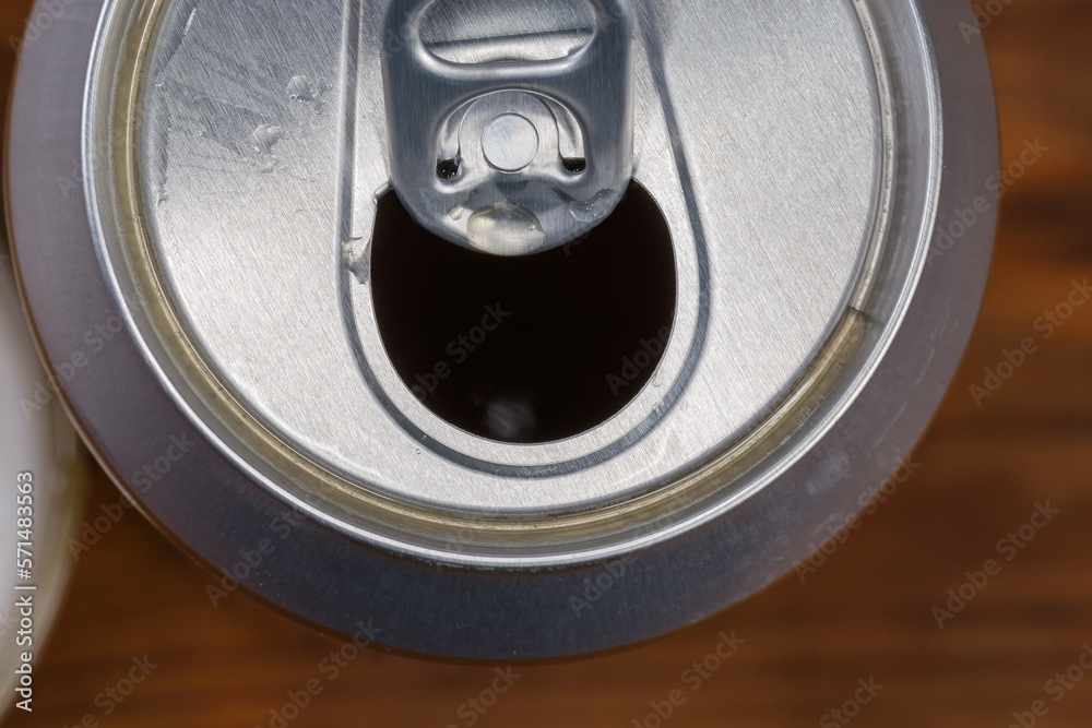 Top view of open beer can, fragment on blurred background Top view of open beer can, fragment on blurred background