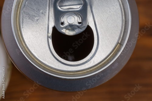 Top view of open beer can, fragment on blurred background