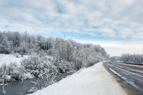 The road is covered with snow and ice for cars, a narrow road after snowfall.