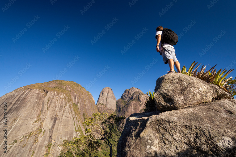 Man posing near dramatic rocky mountain peaks on the rainforest Man posing near dramatic rocky mountain peaks on the rainforest