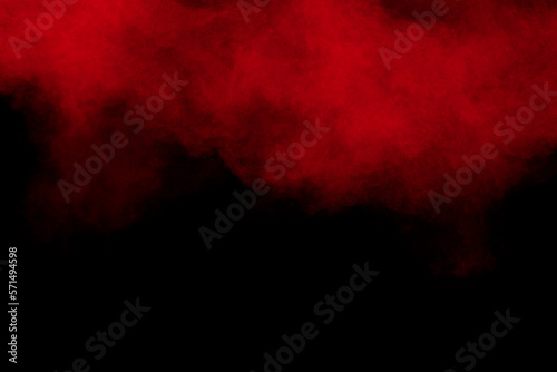 Red color powder explosion on black background.Freeze motion of red dust particles splashing.