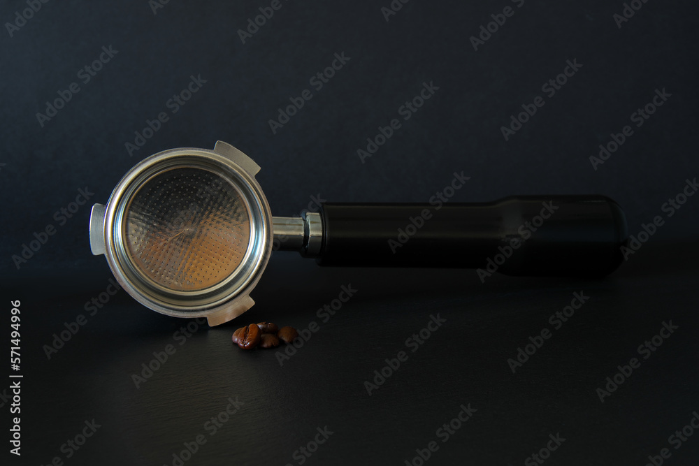 portafilter and roasted coffee beans on a black background.