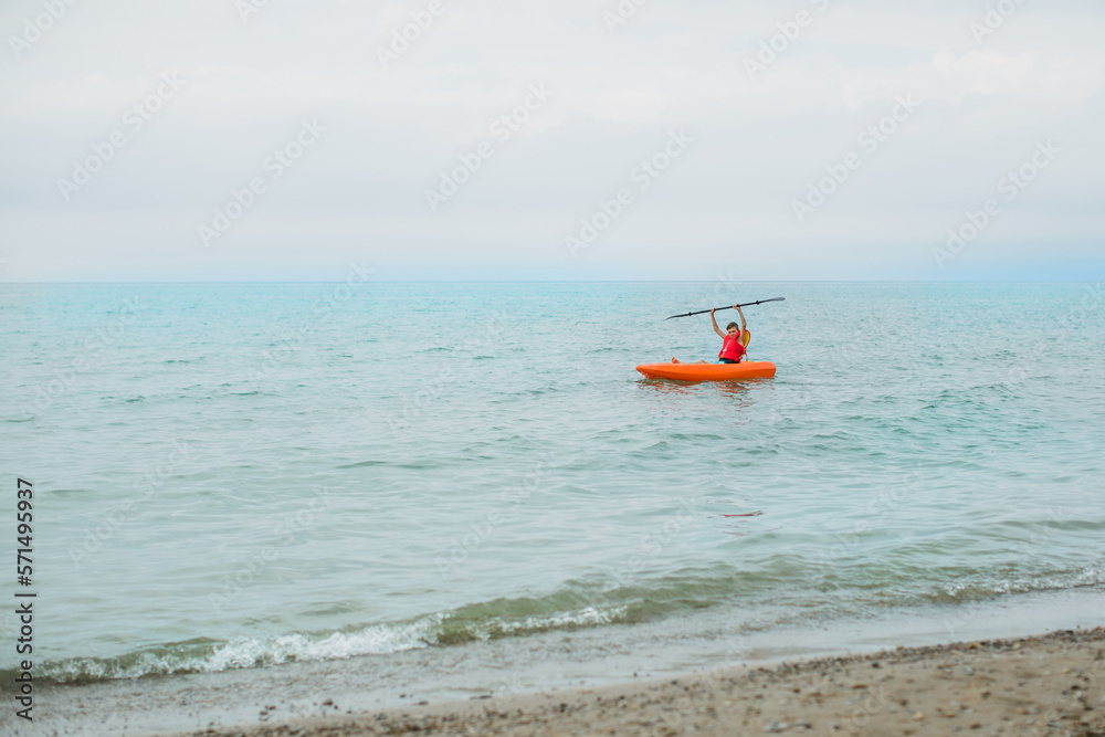 Teen boy on the lake in a kayak during summer vacation in Ontario Teen boy on the lake in a kayak during summer vacation in Ontario