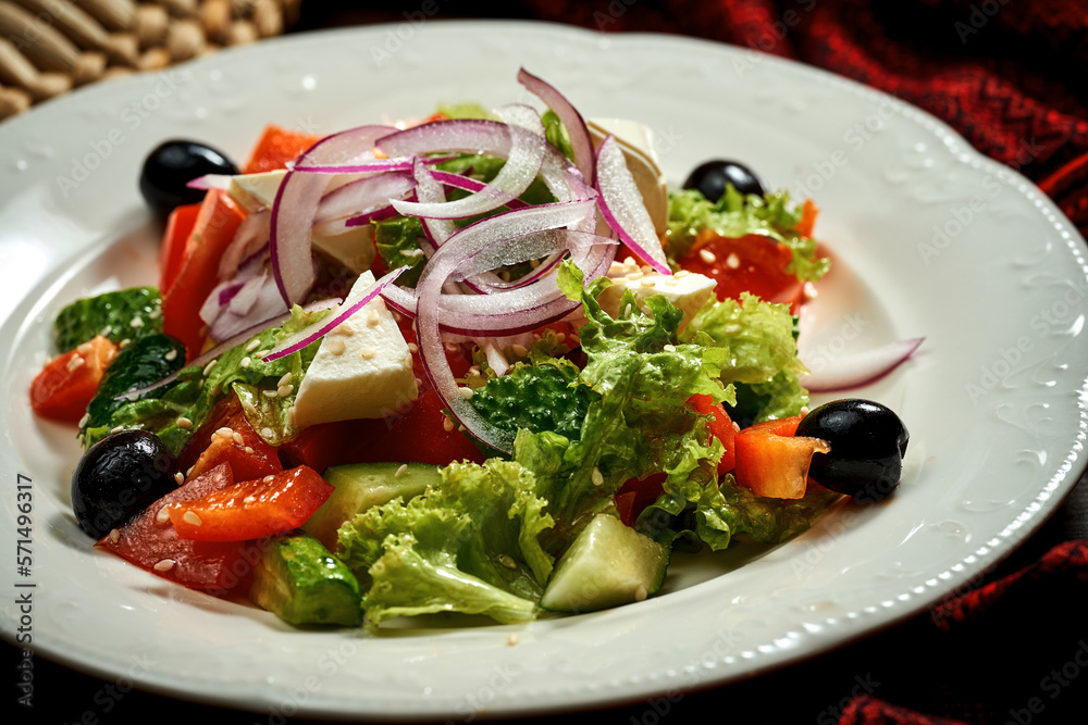 Greek salad with olives and feta cheese in a white plate.
