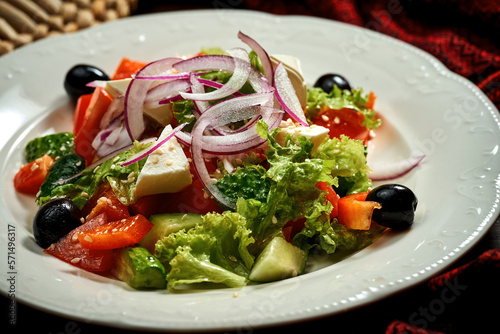 Greek salad with olives and feta cheese in a white plate.