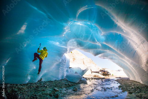 Man ice climbing in ice cave during luxury adventure tour.
