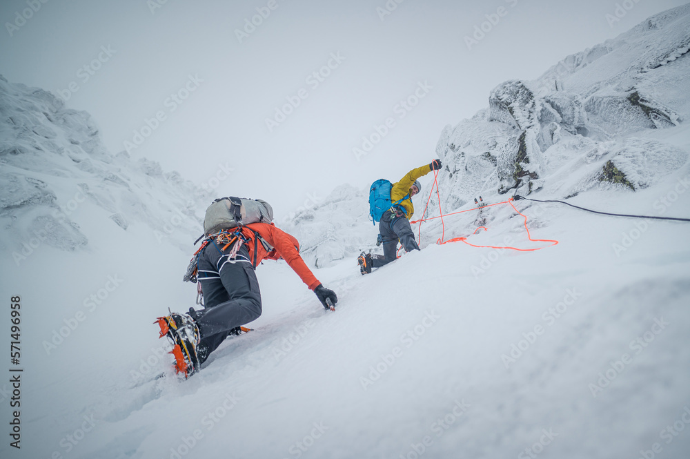 Male mountaineers ice climbing in snowy and frosty conditions Male mountaineers ice climbing in snowy and frosty conditions