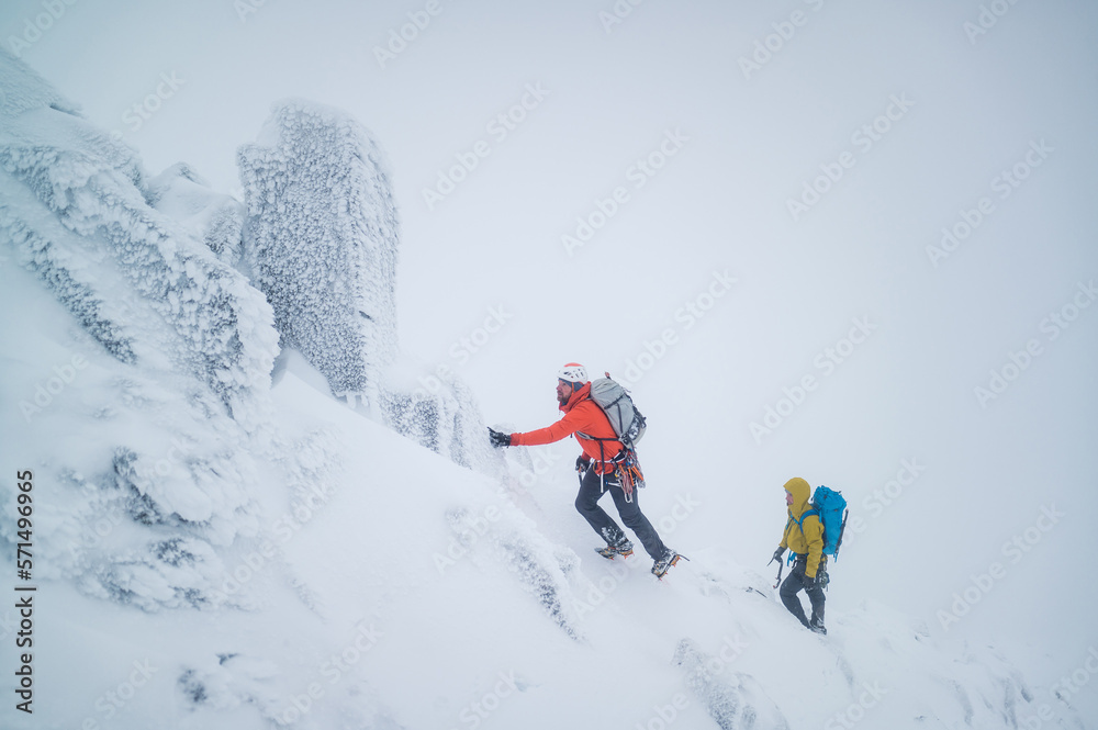 Ice climbers climbing a frozen alpine ridge on a mountain Ice climbers climbing a frozen alpine ridge on a mountain